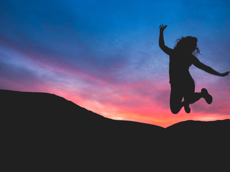 Resilient child jumping with sunset in the background